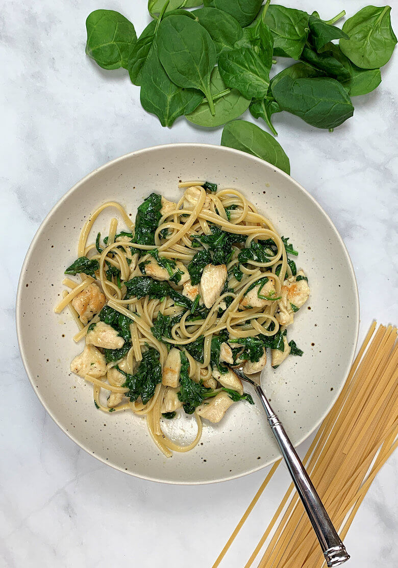 Bowl with chicken Florentine pasta with fork.