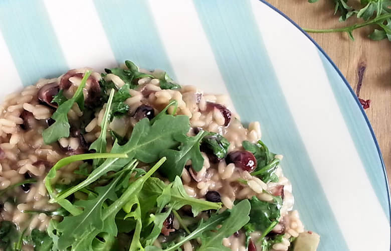 Coconut Risotto with Cranberries and Arugula in Close-up