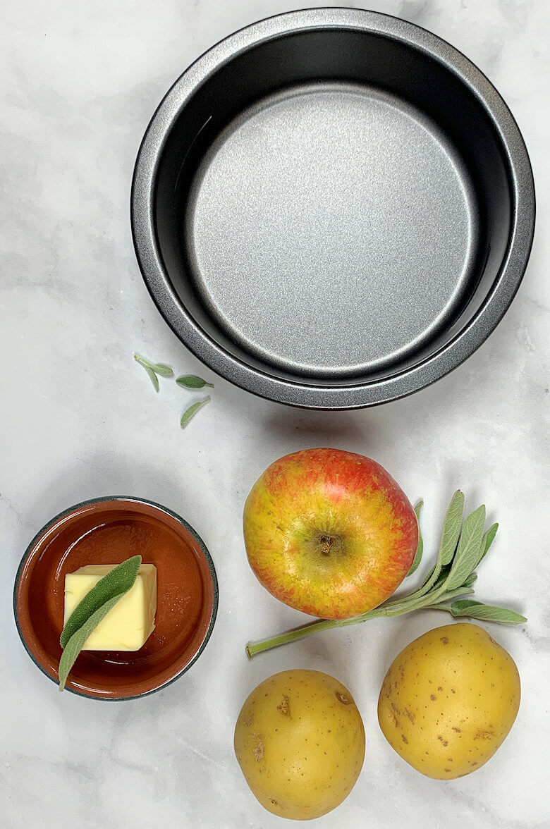 Ingredients of Potato & Apple Galette as well as small pie dish in which the galette is baked.