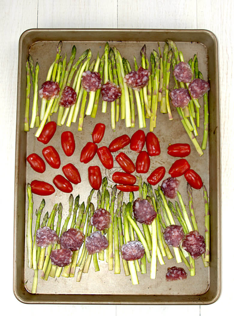 Picture of vegetables and salami on baking sheet ready to roast
