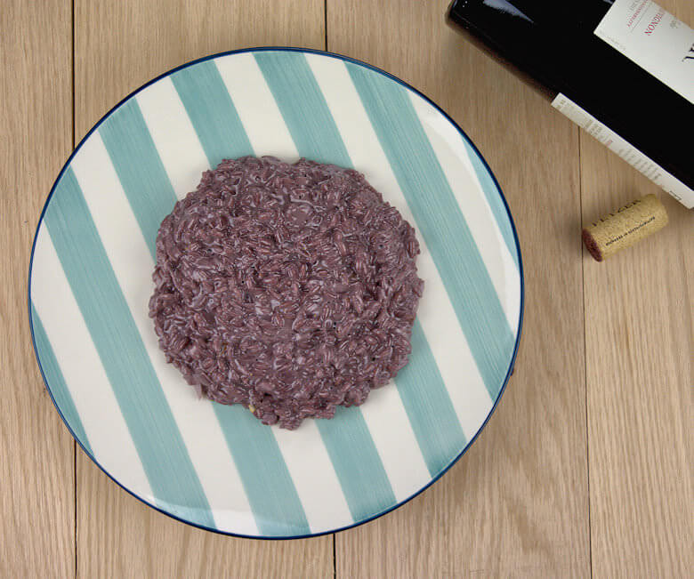 Top down picture of Red Wine Risotto with Mascarpone with a bottle of red wine