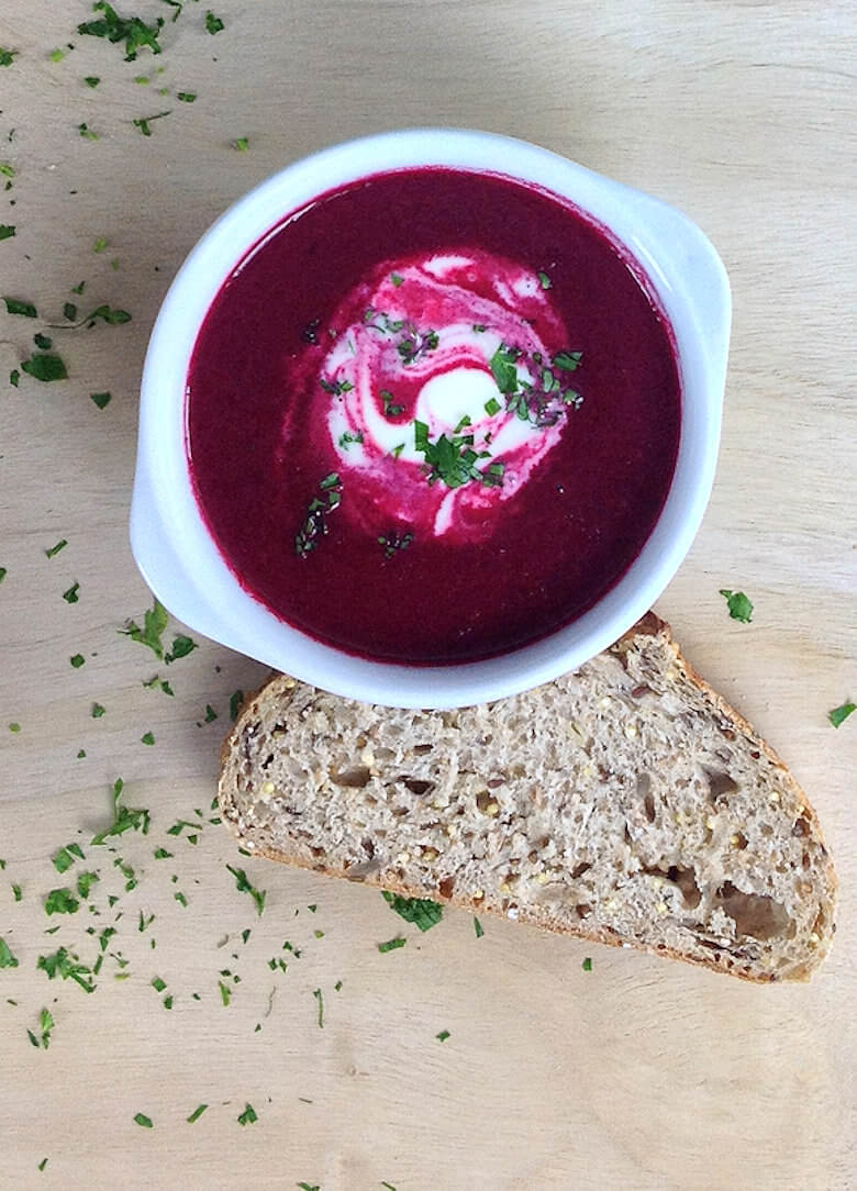 Picture of one bowl of Roasted Beet Soup with Apple and Creme Fraiche with slice of bread