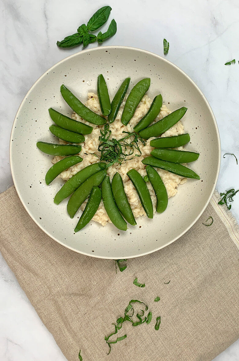 Bowl with Two cheese Risotto and Sugar Snaps and basil on top